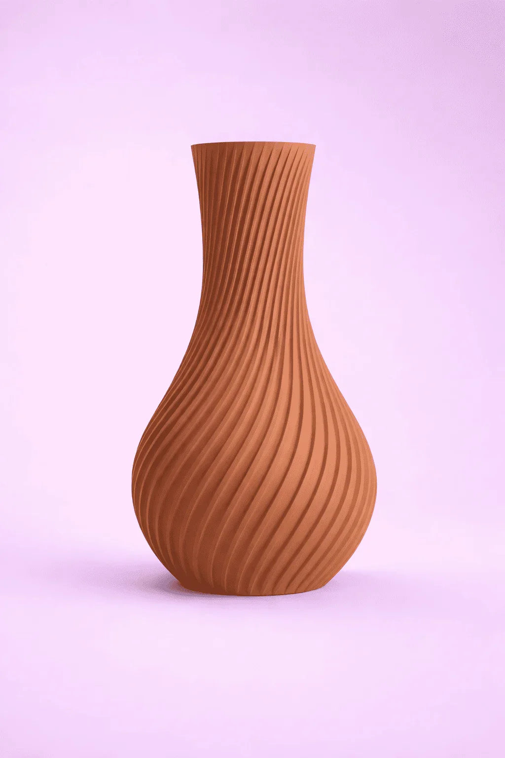 Jarrón marrón de diseño moderno con patrón de espirales sobre fondo rosa.