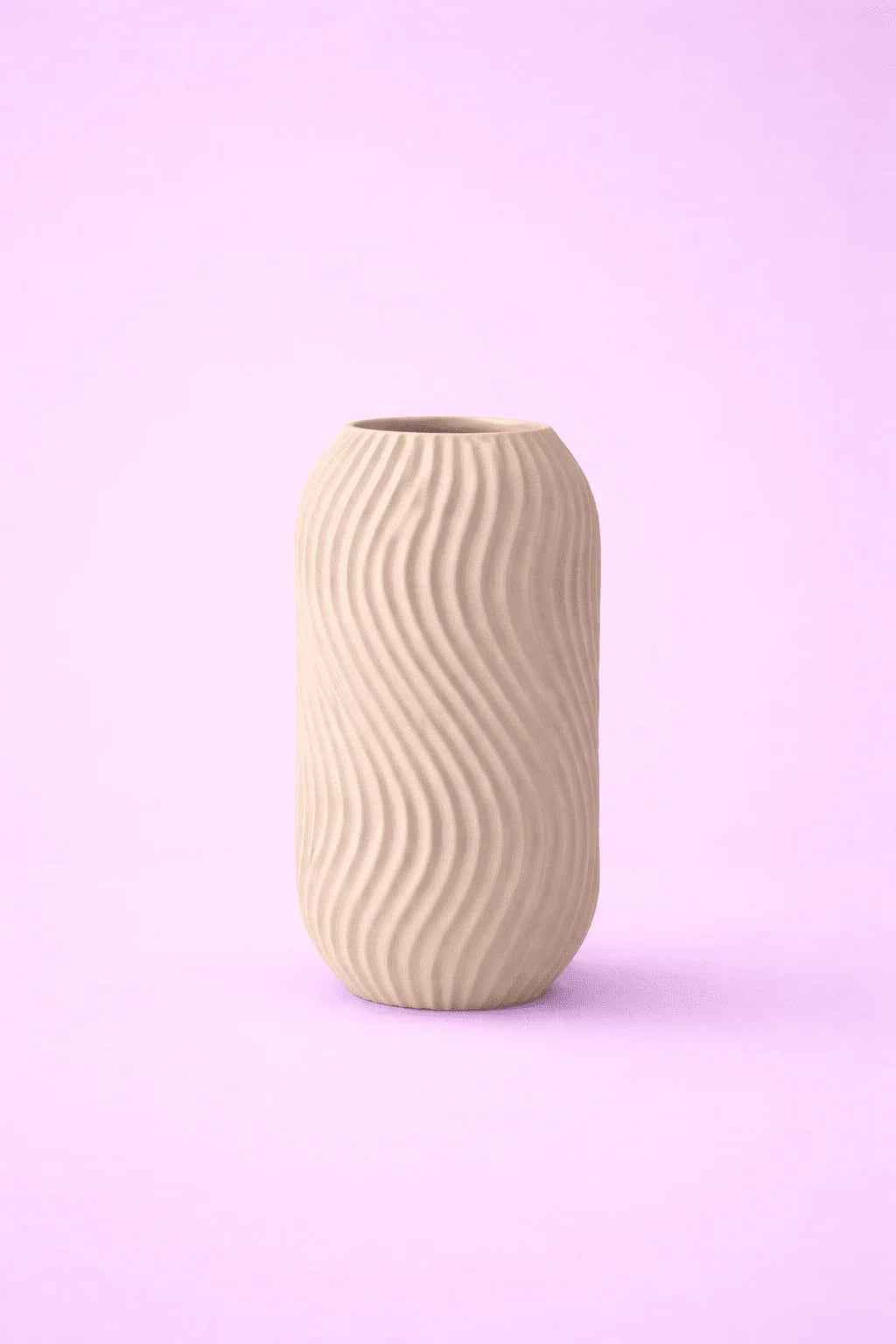 Jarrón beige texturizado de diseño ondulado sobre fondo rosa, decoración minimalista