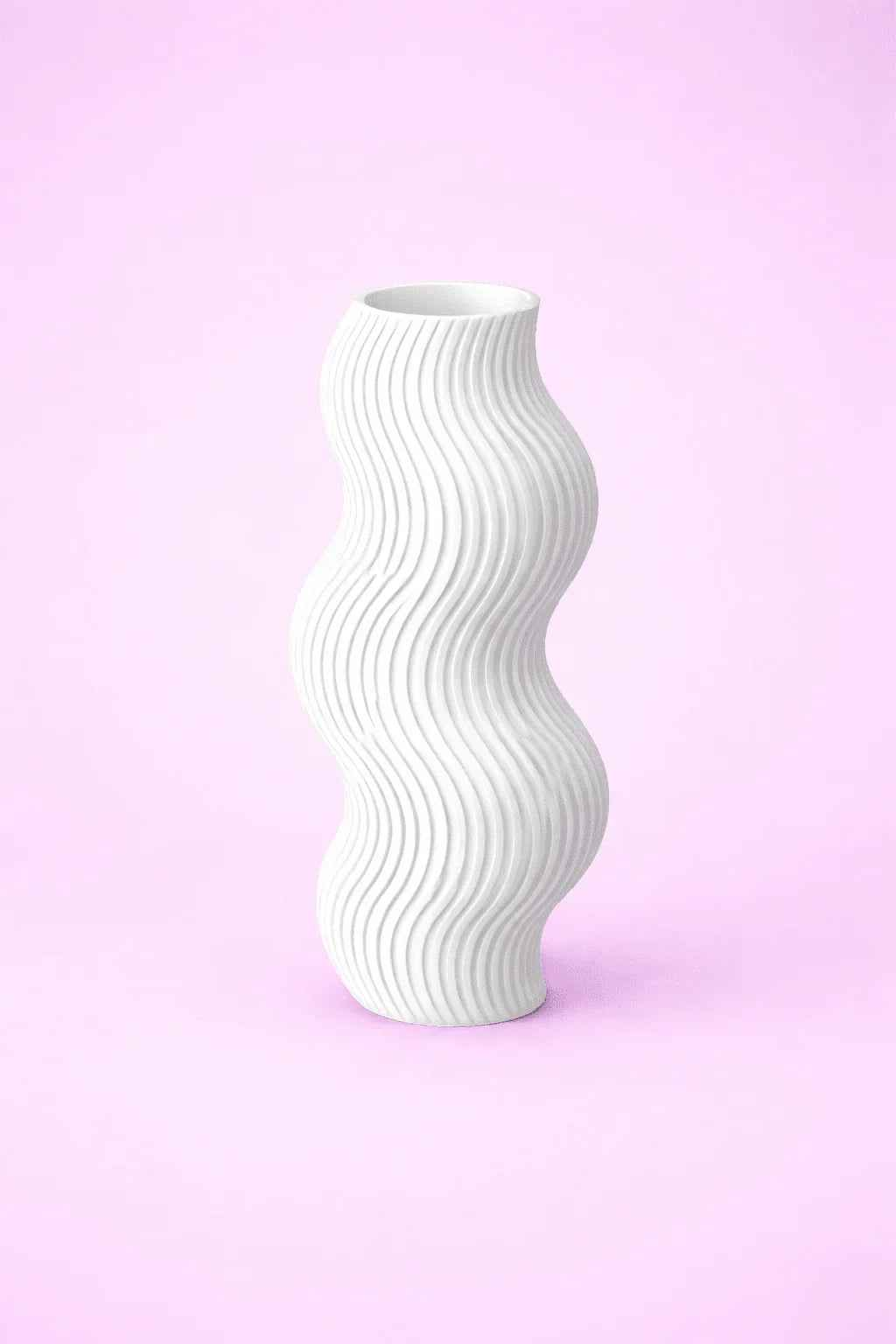 Jarrón blanco de diseño ondulado, impreso en 3D, sobre fondo rosa pastel
