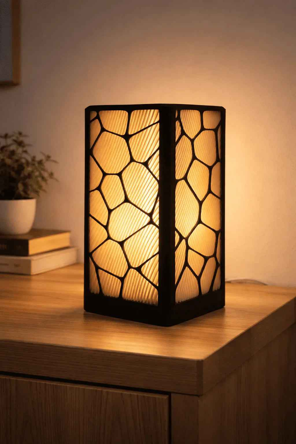 Lámpara decorativa moderna con diseño geométrico iluminada sobre mesa de madera