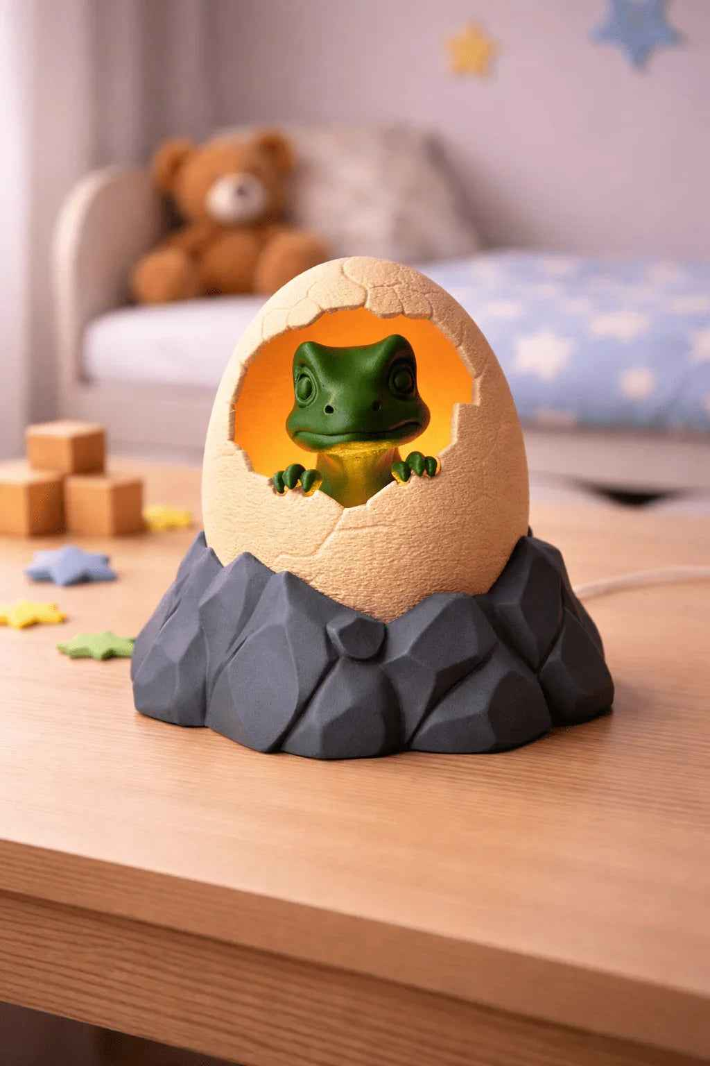 Lámpara infantil decorativa con figura de rana saliendo de huevo sobre mesa en dormitorio