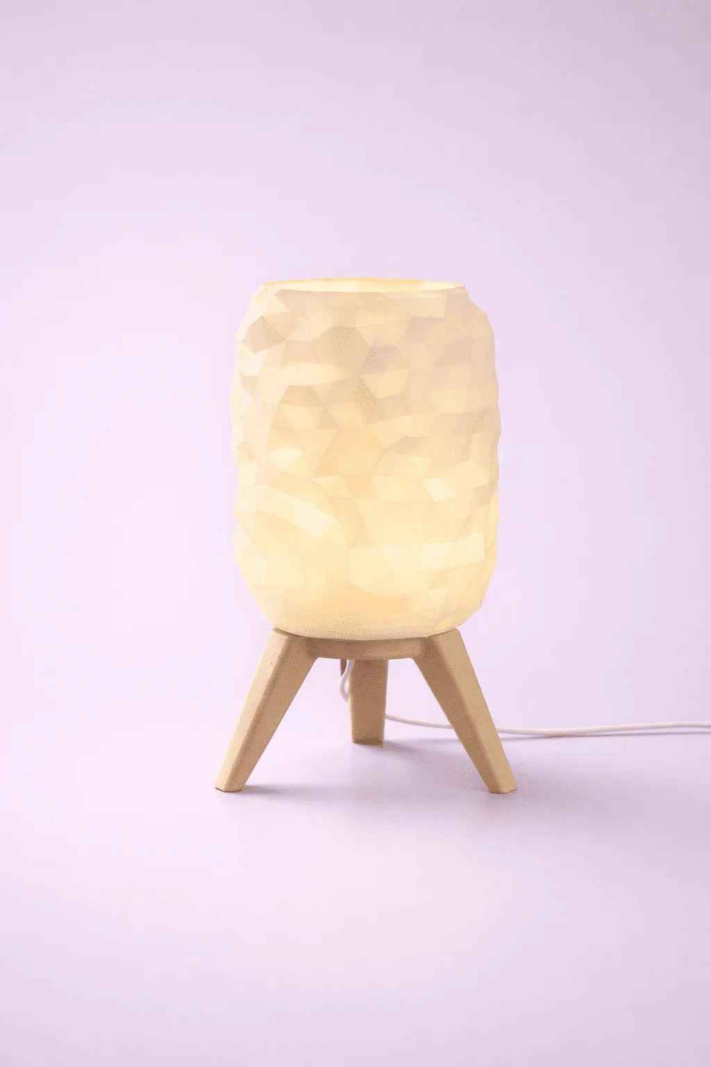Lámpara de mesa diseño geométrico, luz cálida, base de madera, fondo morado claro