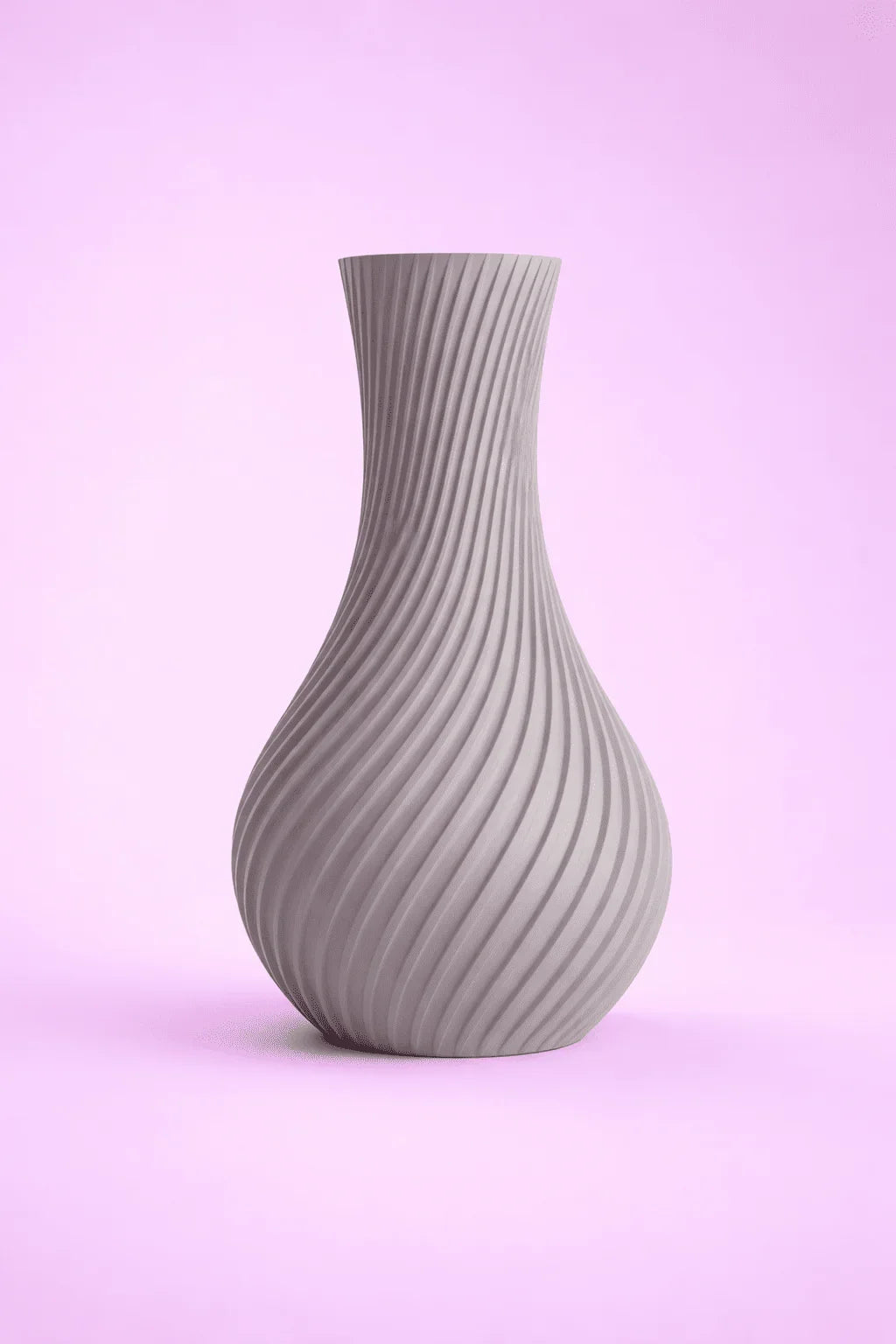 Jarrón gris de diseño moderno con textura en espiral, fondo rosa claro
