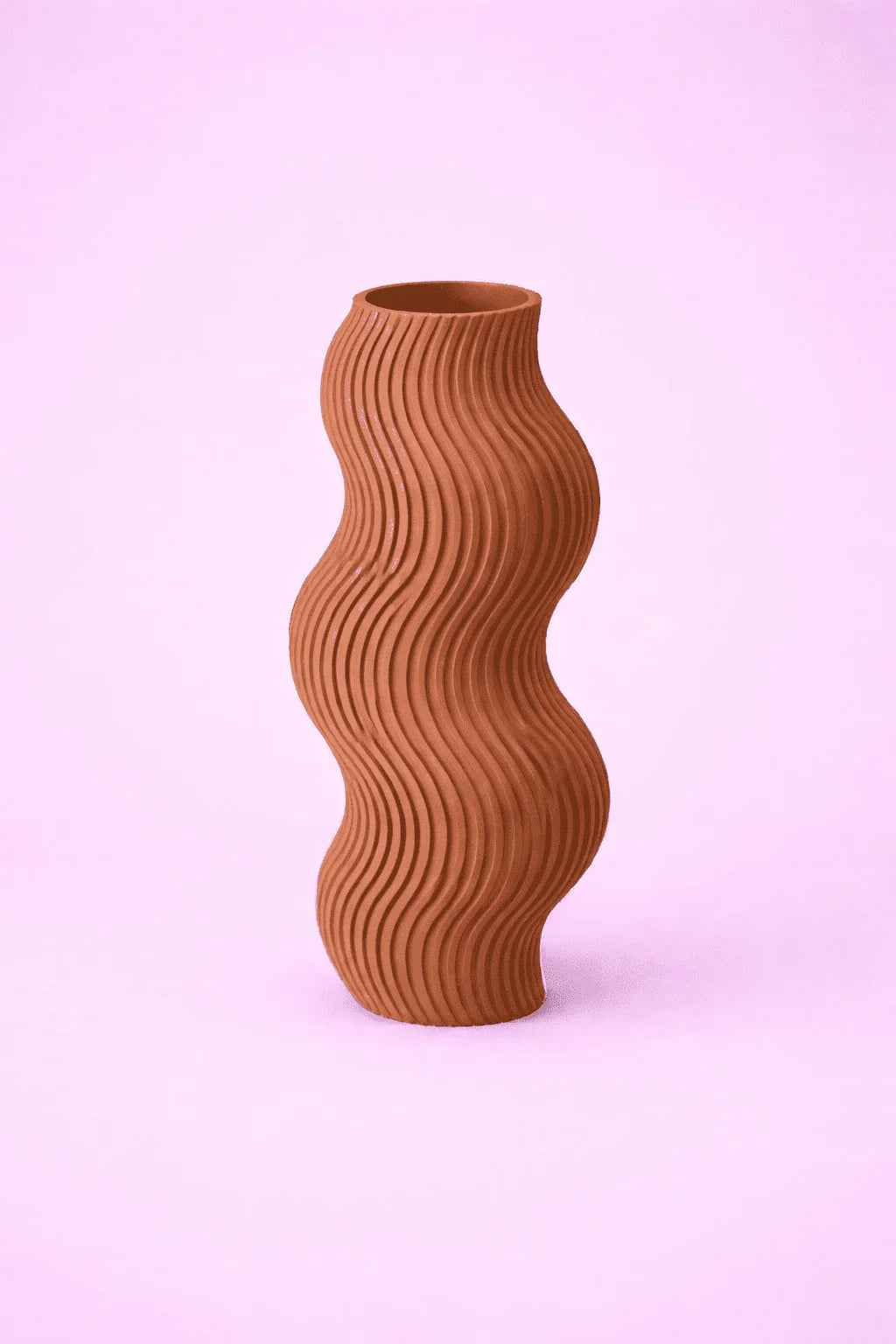 Florero marrón ondulado de cerámica con textura moderna sobre fondo rosa