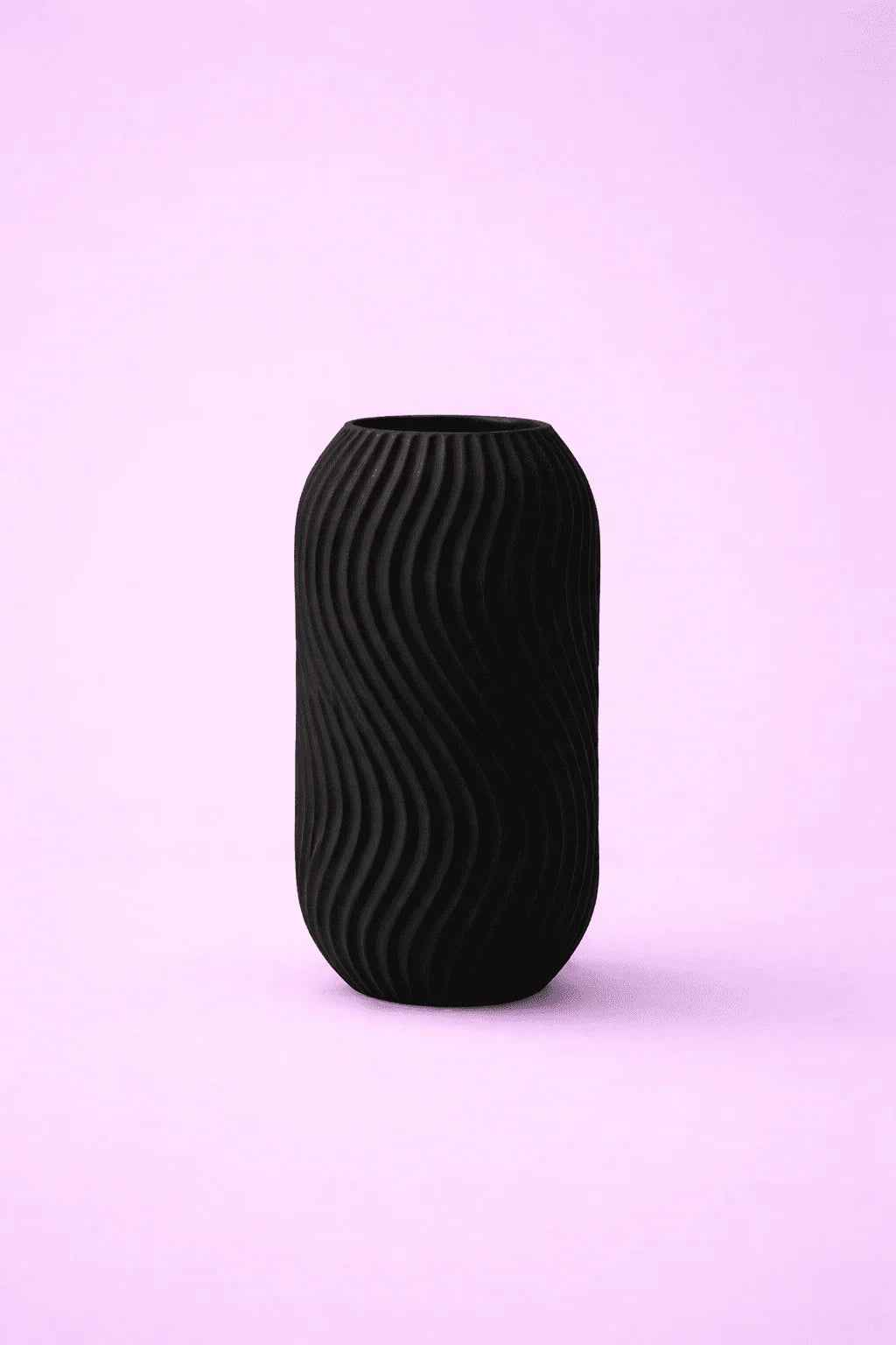 Jarrón negro de diseño 3D con textura ondulada sobre fondo lila minimalista