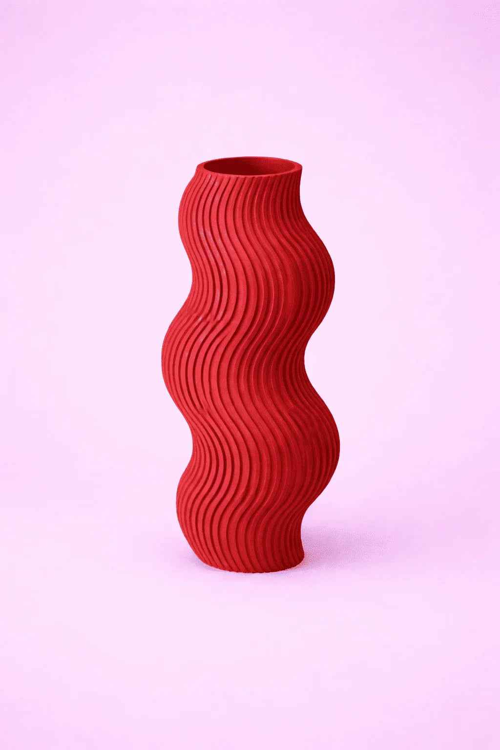 Jarrón rojo ondulado decorativo impreso en 3D sobre fondo rosa